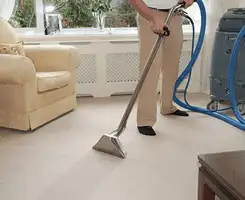Carpet cleaning professional removing dirt and stains with a hot-water extraction tool in a home, Atlanta, GA.