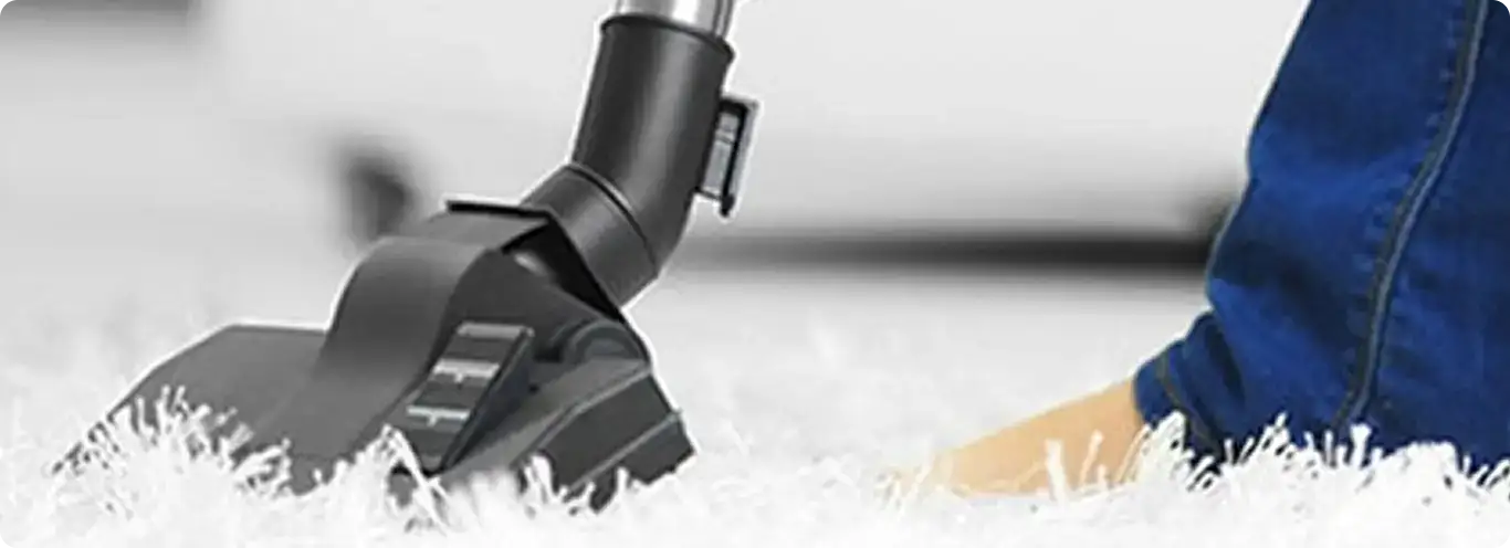 Close-up of a professional vacuuming a white carpet in Decatur.
